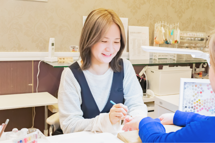 ハンドネイルの施術を行う店長・文山